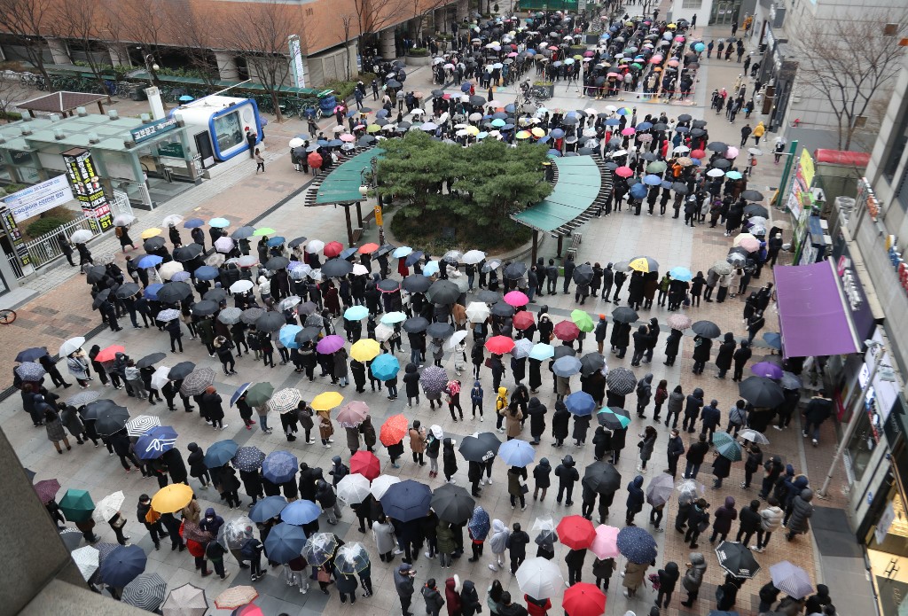 People wait in line to buy face masks from a department store in Seoul on February 28, 2020. - K-pop megastars BTS on February 28 cancelled four concerts they were due to hold in Seoul in April, their agency said, as the coronavirus outbreak spreads in South Korea. The country has so far confirmed more than 2,000 cases of the novel coronavirus, by far the largest national total outside China, the origin of the disease. (Photo by - / YONHAP / AFP) / - South Korea OUT / REPUBLIC OF KOREA OUT  NO ARCHIVES  RESTRICTED TO SUBSCRIPTION USE